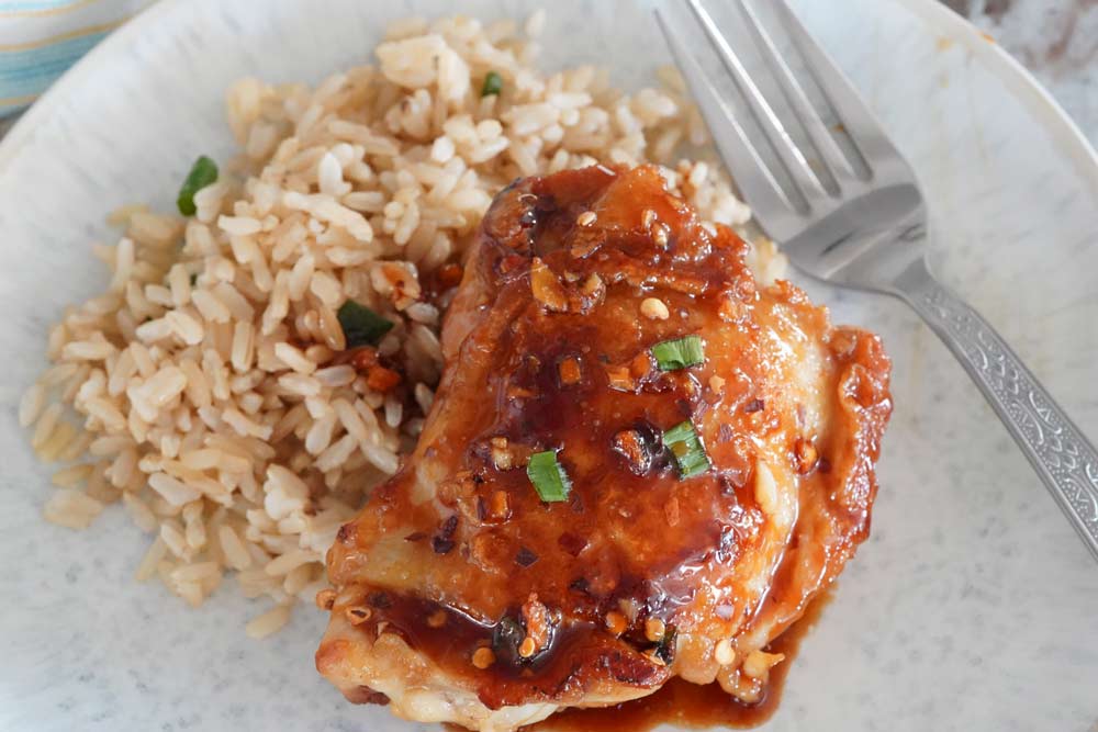 A Honey garlic ginger chicken thigh over rice.
