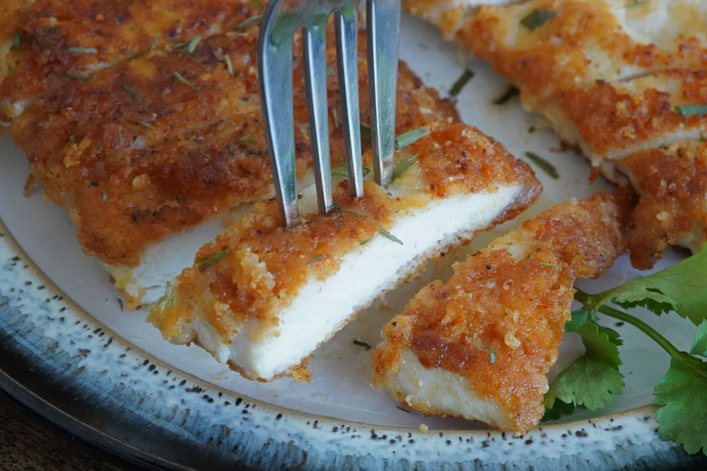 A fork full of parmesan chicken