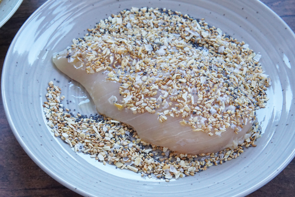 Coating the chicken breast in everything bagel seasoning