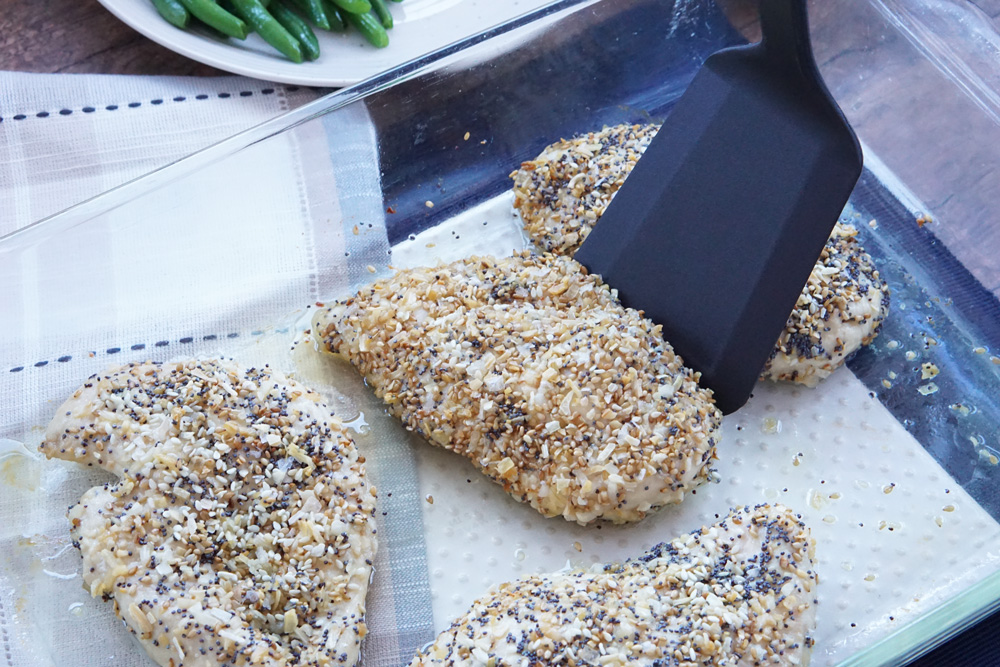 Scooping an everything bagel chicken breast out of the pan