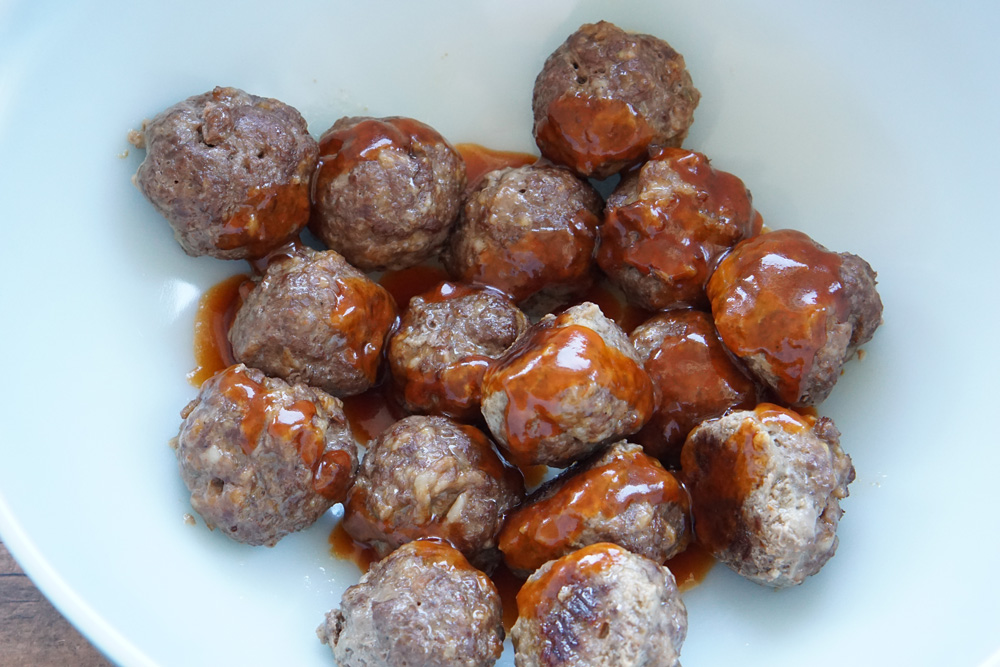 coating the meatballs in honey sriracha sauce