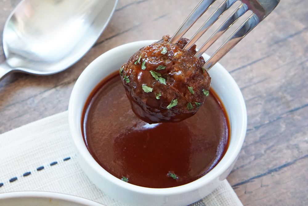 Dipping a meatball into honey sriracha sauce