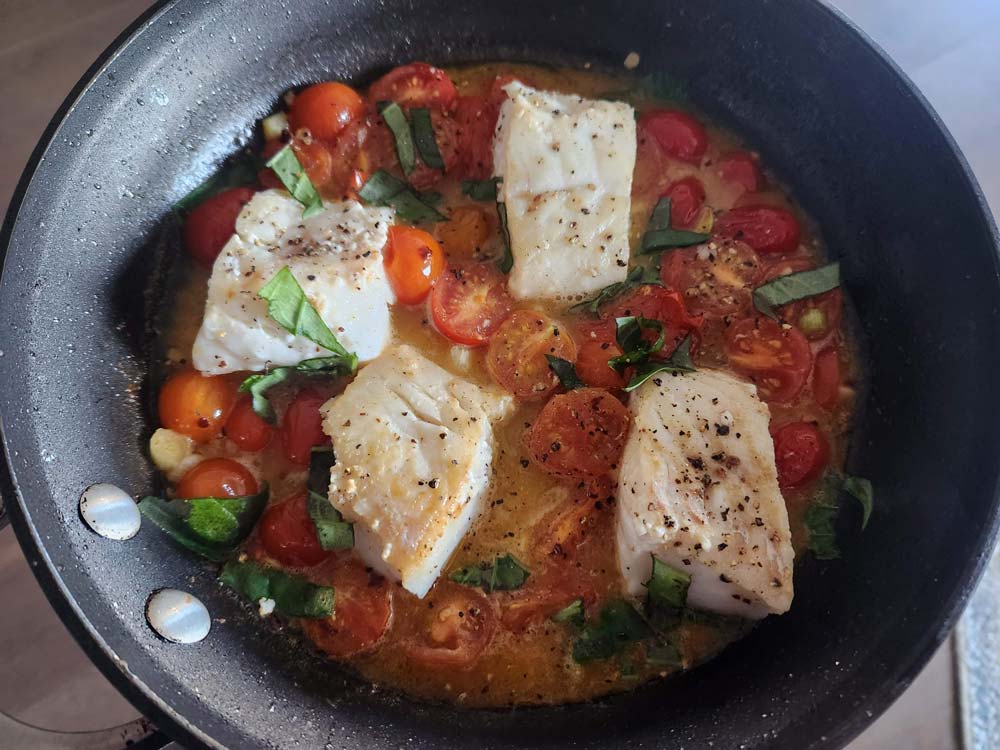 Adding the cod to the sauce.