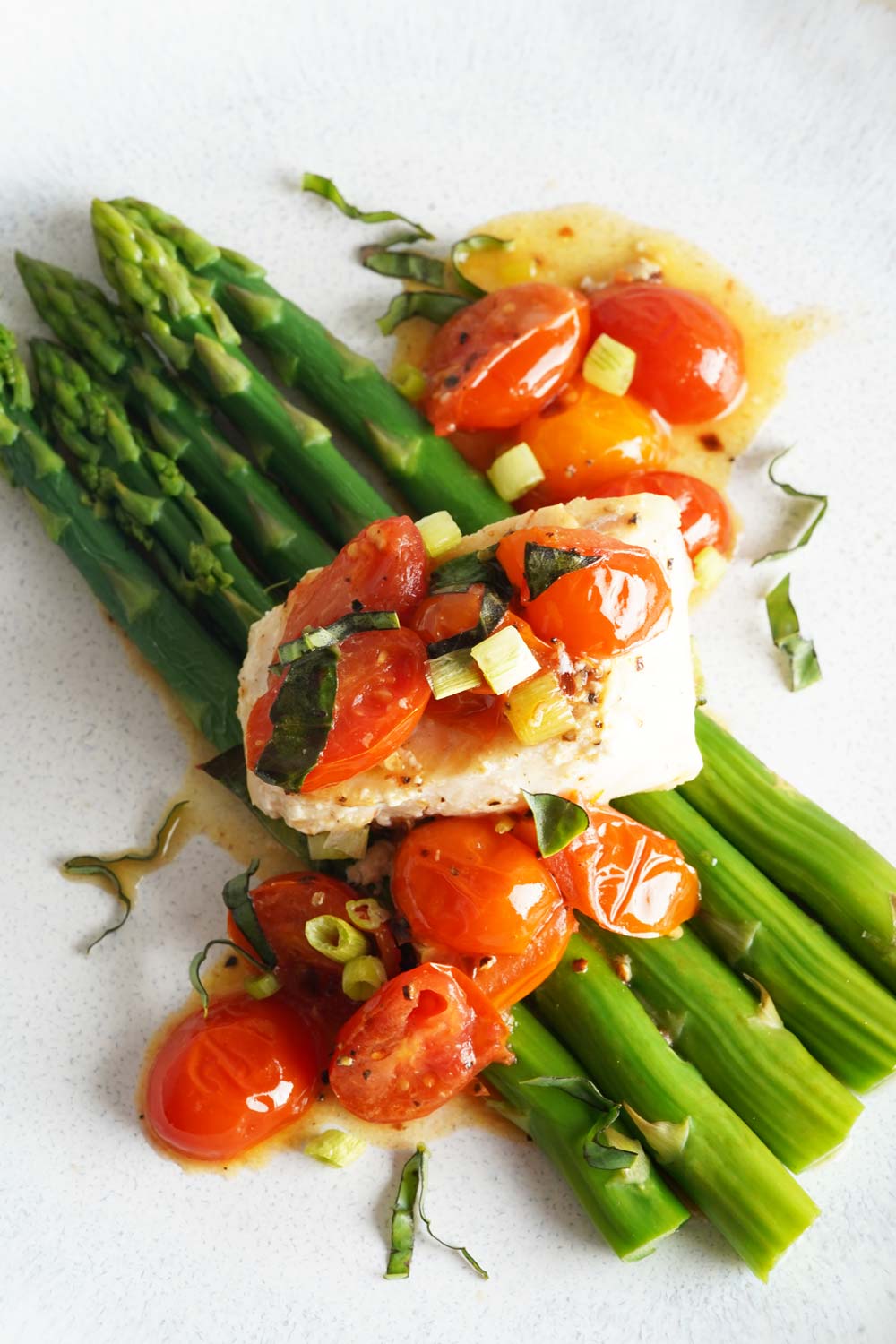 Cod with asparagus in a tomato lemon butter sauce