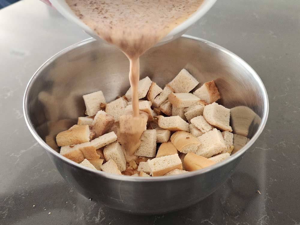 pouring the custard over bread cubes